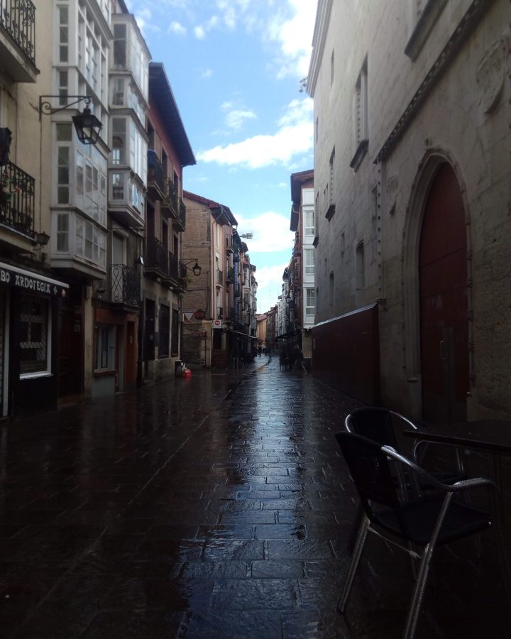 Calle de un casco antiguo con una terraza de bar