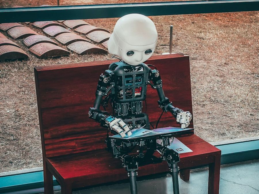 Robot humanoide sentado leyendo, imagen sobre inteligencia artificial